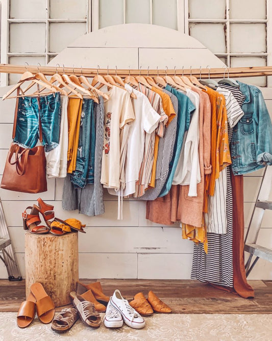 Neatly arranged capsule wardrobe featuring neutral thrifted essentials like jeans, blazers, and white tees — showing how to build a minimalist, sustainable closet with secondhand fashion.
