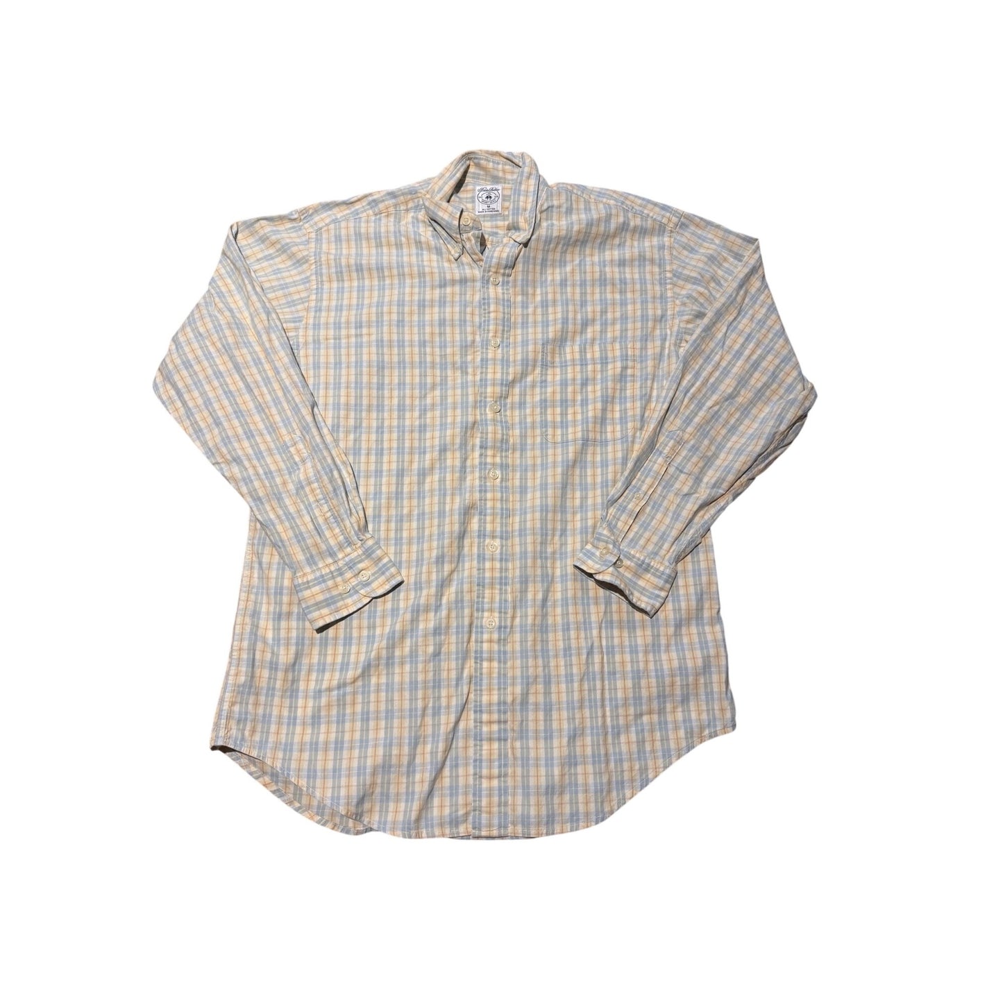 A long-sleeve button-down shirt with a beige, white, and light blue plaid pattern, laid flat against a white background.
