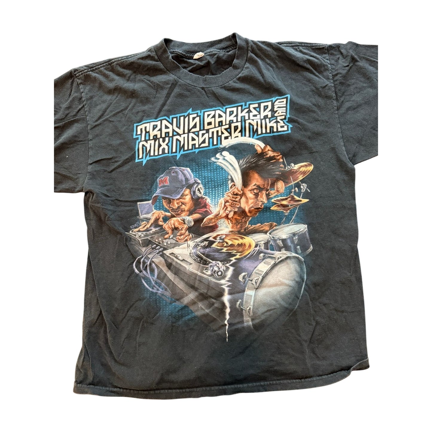 A vintage black graphic t-shirt featuring the text 'TRAVIS BARKER MIX MASTER MIKE' above a colorful illustration of two DJs mixing music with turntables and headphones.