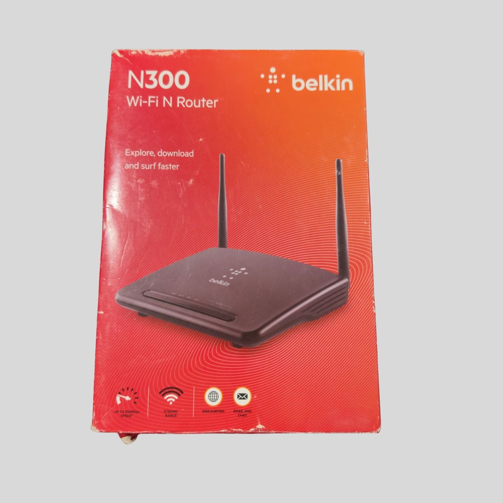 Belkin N300 Wi-Fi N Router retail packaging box, featuring a red-to-orange gradient design with a printed image of the black router and two antennas.