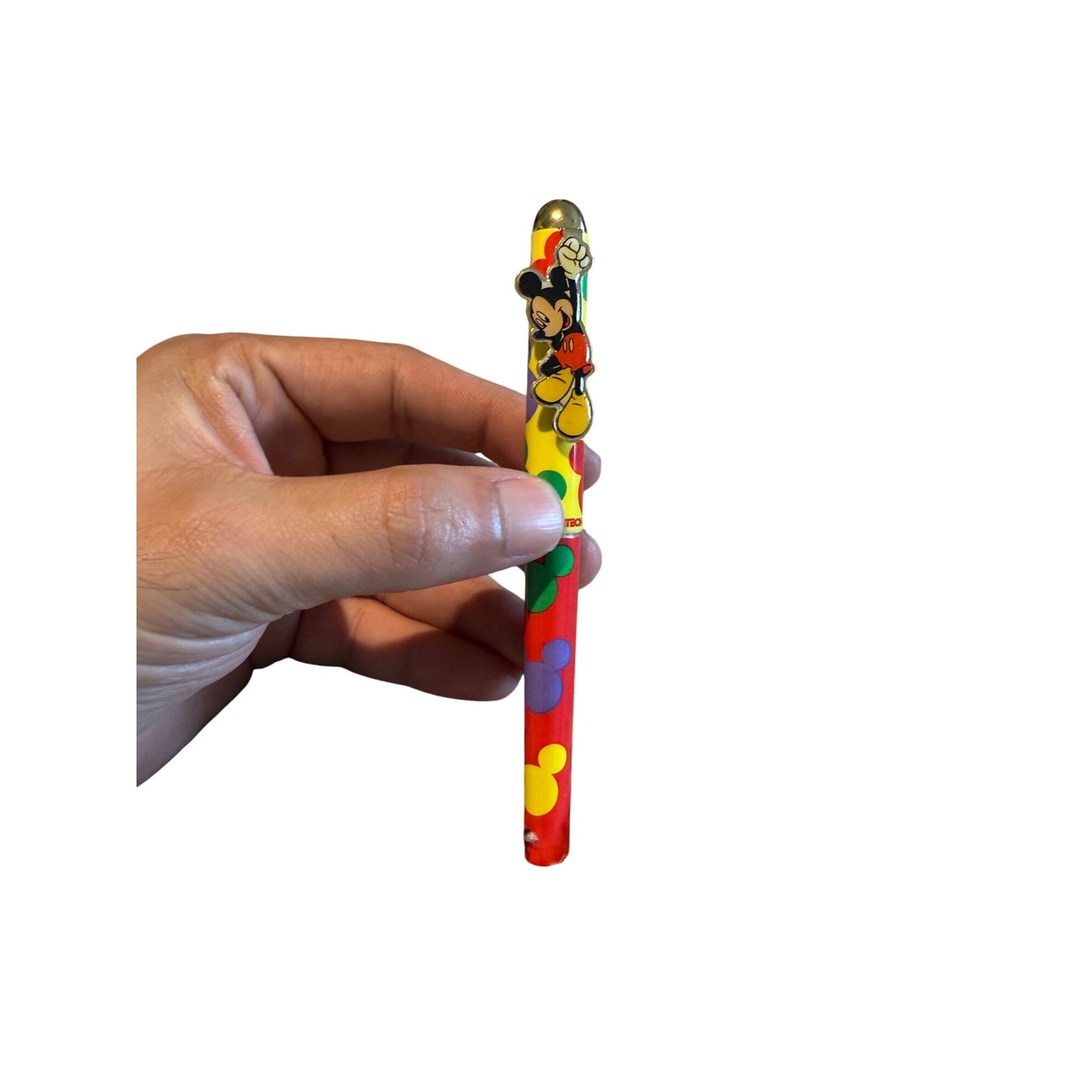 A hand holding a colorful novelty pen featuring Mickey Mouse illustrations on a plain white background.