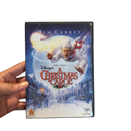 A hand holding a DVD case of Disney's Jim Carrey A Christmas Carol, showing the front cover artwork against a plain white background.